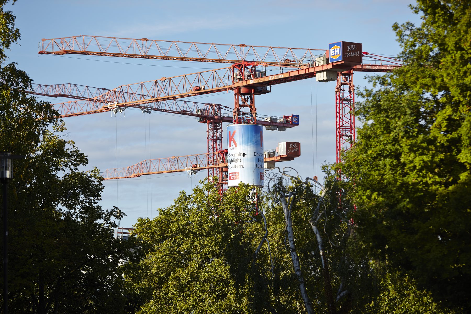 Beleuchtete Kranwerbung am Turmdrehkran eines Bauprojekts